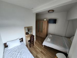 a bedroom with two beds and a desk and a mirror at Hotel & Restaurant Ada in Gusinje