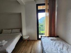 een slaapkamer met 2 bedden en een groot raam bij Hotel & Restaurant Ada in Gusinje
