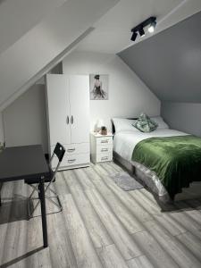 a bedroom with a bed and a desk and a bed sidx sidx sidx at P Williams Plumstead in Plumstead