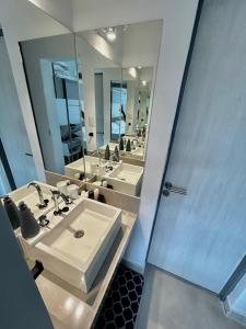 a bathroom with three sinks and a large mirror at Reina Mora Hotel in La Rioja