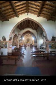 una iglesia con una gran habitación con bancos de madera en appartamento la Bastia fra il lago di Garda e Brescia città, en Nuvolento