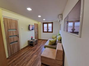 a living room with a couch and a door at Stela Apartman Štúrovo in Štúrovo