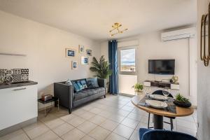 ein Wohnzimmer mit Sofa und Tisch in der Unterkunft Appartement "Côté canal", Terrasse , Climatisation , parking privé in Narbonne