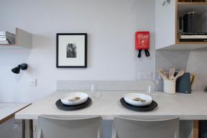 a kitchen table with two bowls and plates on it at Keel House refurbished Studios in Edinburgh