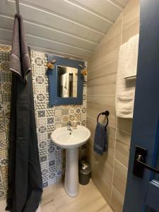 ein Bad mit einem Waschbecken und einem Spiegel in der Unterkunft Sea Breeze cabin in Donegal