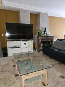 a living room with a black couch and a flat screen tv at Villa los Cantos in Toledo