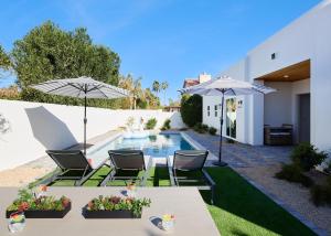 a backyard with a pool and two chairs and umbrellas at Monroe - Brand-New Remodel - Backyard Oasis in Phoenix