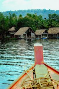 um barco na água com um grupo de casas em Thansur Tatai Eco Resort em Tatai