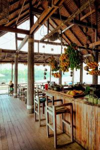 um restaurante com mesas e cadeiras e um balcão com bananas em Thansur Tatai Eco Resort em Tatai