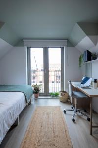 a bedroom with a bed and a desk with a laptop at Keel House refurbished Studios in Edinburgh