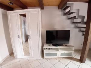 a living room with a tv and a staircase at Ognina Marina Gem in Catania