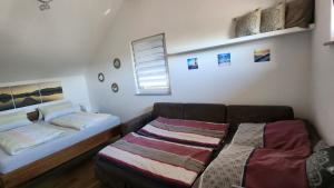 a room with two beds and a couch and a window at Zettis Ferienhäusle in Berg bei Ravensburg