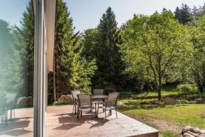 un patio con mesa y sillas en una terraza en Nettes Ferienhaus in Ruhla mit Garten, Grill und Sauna, en Ruhla