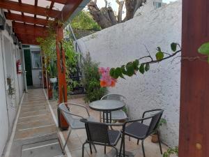 d'une terrasse avec une table, des chaises et une clôture. dans l'établissement Ríos que nos unen, à Colonia del Sacramento