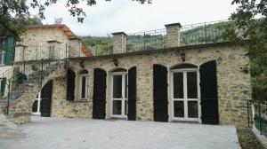 un gran edificio de ladrillo con ventanas blancas y balcón en Ferienhaus in Stellanello mit Terrasse, Grill und Garten, en Testico