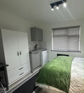 1 dormitorio con 1 cama y cocina en P Williams Plumstead en Plumstead