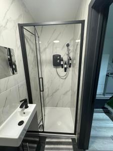 a bathroom with a shower and a white sink at P Williams Plumstead in Plumstead