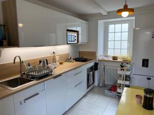 eine Küche mit weißen Schränken und einer Spüle in der Unterkunft Maison de vacances hyper centre, plage à pied - Etables sur Mer in Étables