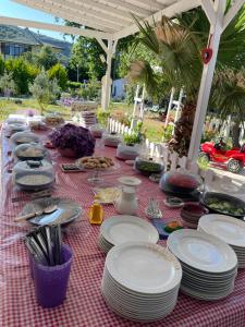 a table with plates and utensils on a red checked table cloth at Adasu Otel in Marmara