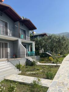 a house with a walkway in front of it at Adasu Otel in Marmara