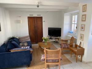 ein Wohnzimmer mit einem blauen Sofa und einem Tisch in der Unterkunft Maison de vacances hyper centre, plage à pied - Etables sur Mer in Étables