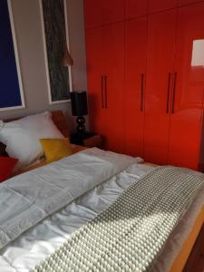 a bed with red cabinets in a bedroom at Sloneczny Apartament na 14 Kondygnacji z widiokiem na Bydgoszcz in Bydgoszcz