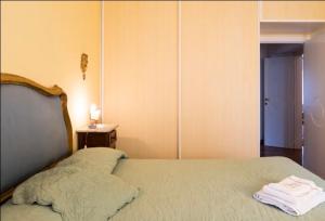 um quarto com uma cama com um edredão branco em Cozy room in Palazzo Magnalbò em Macerata