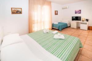 a hotel room with two beds and a television at Hotel Fernanda in Letojanni