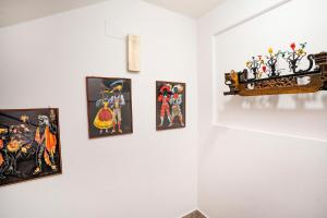 a group of paintings on a white wall at Hotel Fernanda in Letojanni
