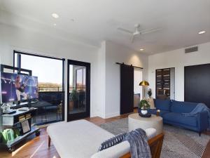 a living room with a blue couch and a tv at Sly Fox - Private Balcony - 12 South in Nashville