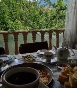 a table with plates of food on a balcony at Panoramic Tufandag family Apartment in Gabala