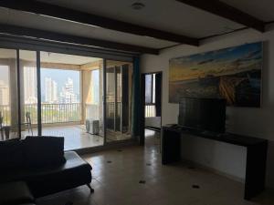 a living room with a couch and a large window at Amazing penthouse with stunning views & pool in Cartagena de Indias