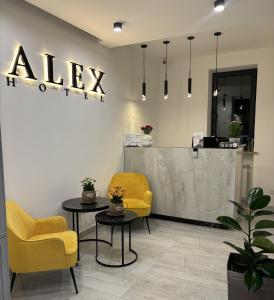 エレバンにあるAlex Hotelの黄色い椅子2脚とテーブルが備わる待合室