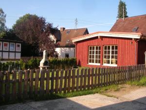 a red house with a fence in front of it at Ferienhaus "Lena" in Presseck