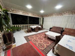 porche cubierto con sofá, mesa y sillas en Panoramic Tufandag family Apartment, en Gabala
