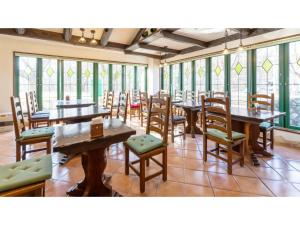 una sala da pranzo con tavoli, sedie e finestre di SHIZUKUISHI RESORT HOTEL - Vacation STAY 29562v a Shizukuishi