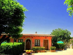 una casa de ladrillo rojo con árboles y arbustos en Ferienwohnung in Poggio Alla Cavalla mit Privatem Garten, en Lamporecchio