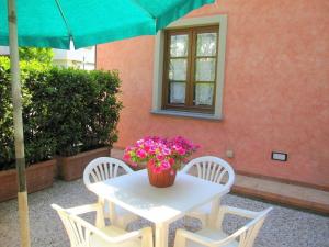 una mesa con dos sillas y una mesa con flores. en Ferienwohnung in Poggio Alla Cavalla mit Privatem Garten, en Lamporecchio