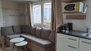 a small living room with a couch and a kitchen at Les sables du midi in Valras-Plage