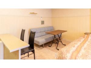 Zimmer mit Sofa, Tisch und Bett in der Unterkunft SHIZUKUISHI RESORT HOTEL - Vacation STAY 29557v in Shizukuishi