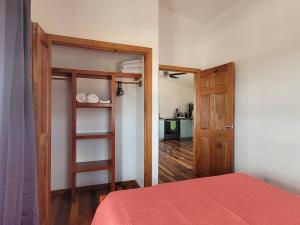 Pokój z łóżkiem, drzwiami i kuchnią w obiekcie K'onjo Bet (Beautiful House) @ Secret Beach w mieście San Pedro
