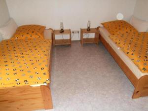 dwa łóżka w pokoju z dwoma stolikami nocnymi w obiekcie Ferienhaus Steinachtal in Franken bis 5 Personen - b48519 w mieście Marktgraitz