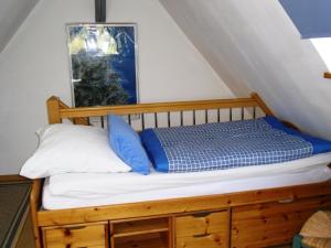 1 cama con almohadas azules y blancas en una habitación en Komfortables Ferienhaus mit eigener Sauna en Gunzenhausen