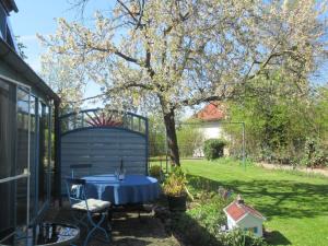 una mesa en un jardín con un árbol en el patio en Komfortables Ferienhaus mit eigener Sauna, en Gunzenhausen
