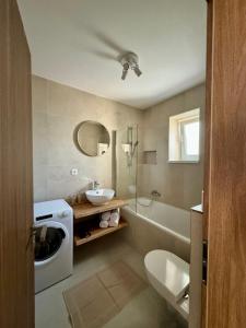 La salle de bains est pourvue d'un lavabo, de toilettes et d'une baignoire. dans l'établissement Apartment ZOi, à Šamorín