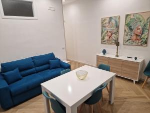 uma sala de estar com um sofá azul e uma mesa em Casa Gaia em Terrasini