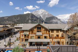 a large building with a mountain in the background at Brewster Mountain Lodge in Banff