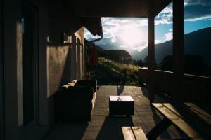 a couch sitting on a porch with a view of the mountains at Neues Ferienhaus in Sankt Margarethen Im Lungau mit Großer Terrasse in Sankt Margarethen im Lungau