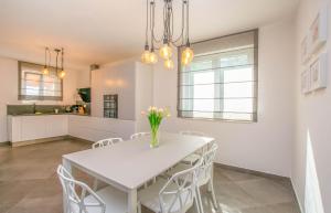 a kitchen and dining room with a white table and chairs at House Villa Verdi in Tkon