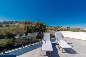 a group of white chairs sitting on a patio at House Villa Verdi in Tkon